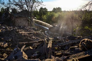 Ukrainian rescuers work at the site of a glide bomb attack on a private building in Vilkhivka village near Kharkiv, northeastern Ukraine